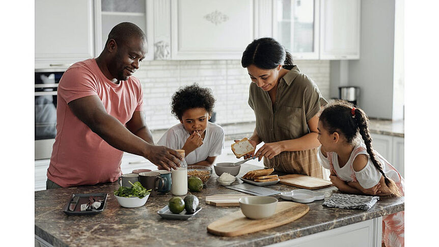 Ein Foto einer Familie mit zwei Kindern am Küchentisch