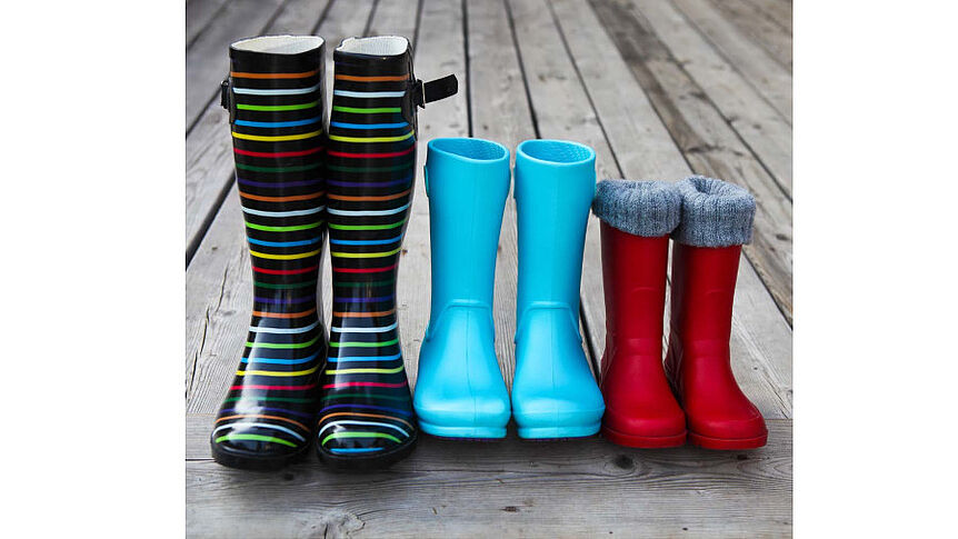 3 Paar bunte Gummistiefel stehen nebeneinander