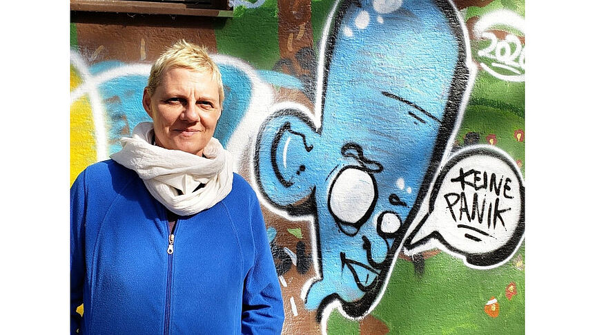 Prof. Kusenbach vor einer Graffiti-Wand